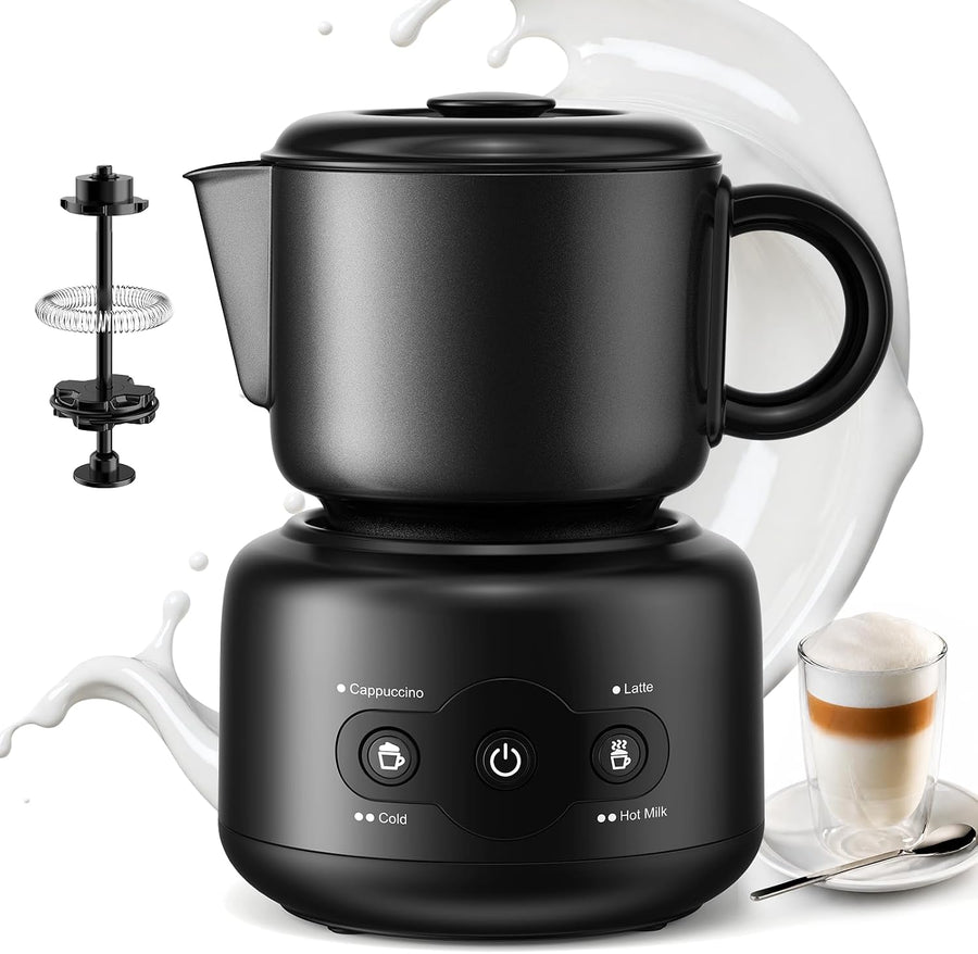 Black electric cappuccino maker with a built-in mug and base, shown on a white background with milk splash graphics, a small accessory basket on the left, and a glass of latte on the right.