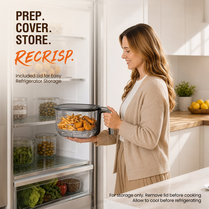 A woman in a beige cardigan stands in a bright kitchen opening a refrigerator to store a Recrisp. air fryer basket.