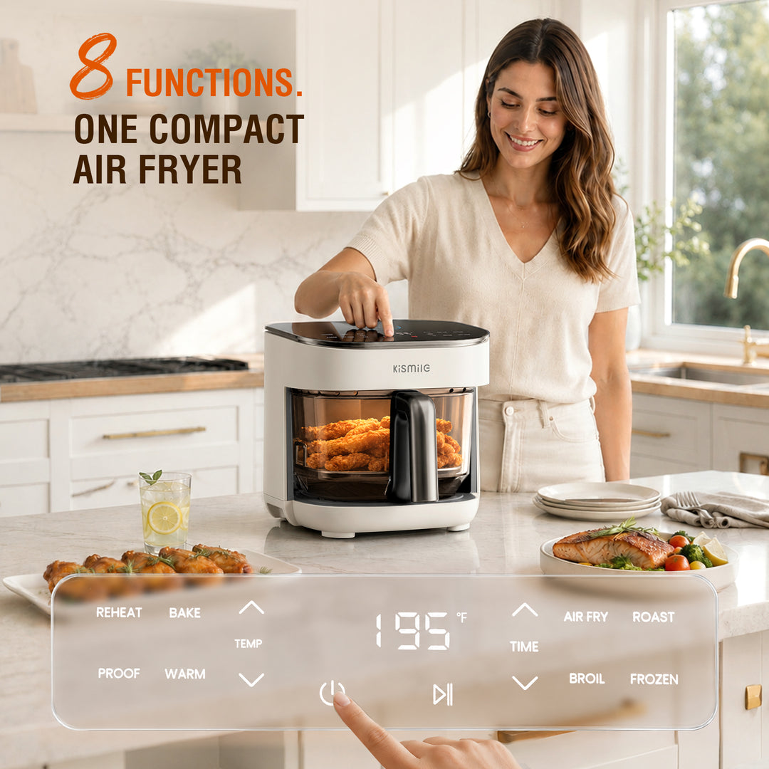 A woman in a bright kitchen uses a compact white and black air fryer with a digital control overlay shown in the foreground. The air fryer is filled with golden fried food, and plates of food are arranged on the counter.