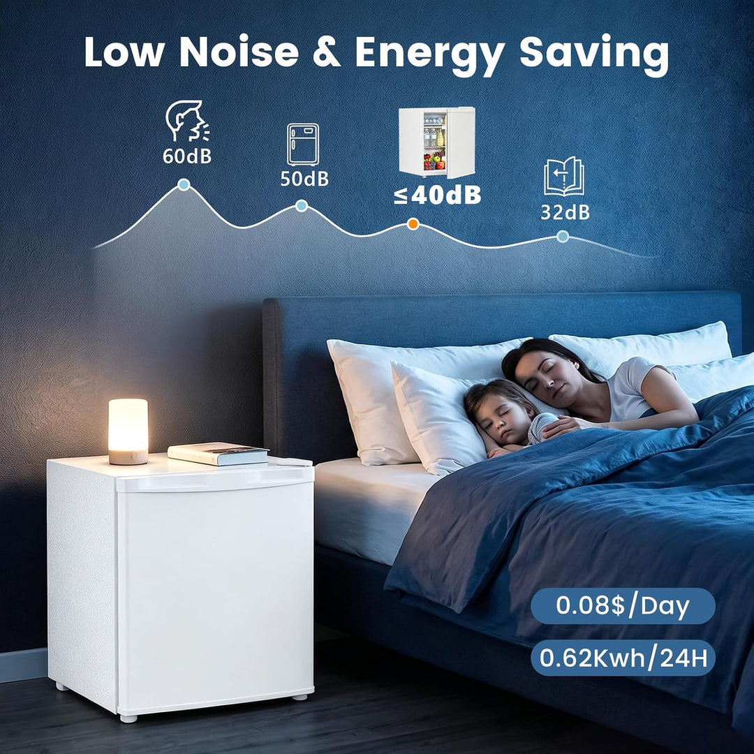 A white mini refrigerator shown beside a bed in a dark bedroom, with a woman and child sleeping under blue bedding. White text at the top reads 'Low Noise & Energy Saving' with decibel performance icons, and blue text at the bottom right shows '0.