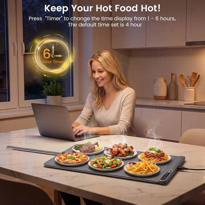A woman sits at a kitchen table using a laptop while a steaming hot food warmer tray holds multiple plates of food. The scene includes promotional text at the top about changing the timer display and a glowing 6-hour timer graphic.