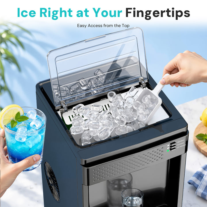 A countertop ice maker shown with a clear lid open, filled with ice cubes, and a hand using a white scoop to add more ice. A hand also holds a blue drink with a lemon garnish.